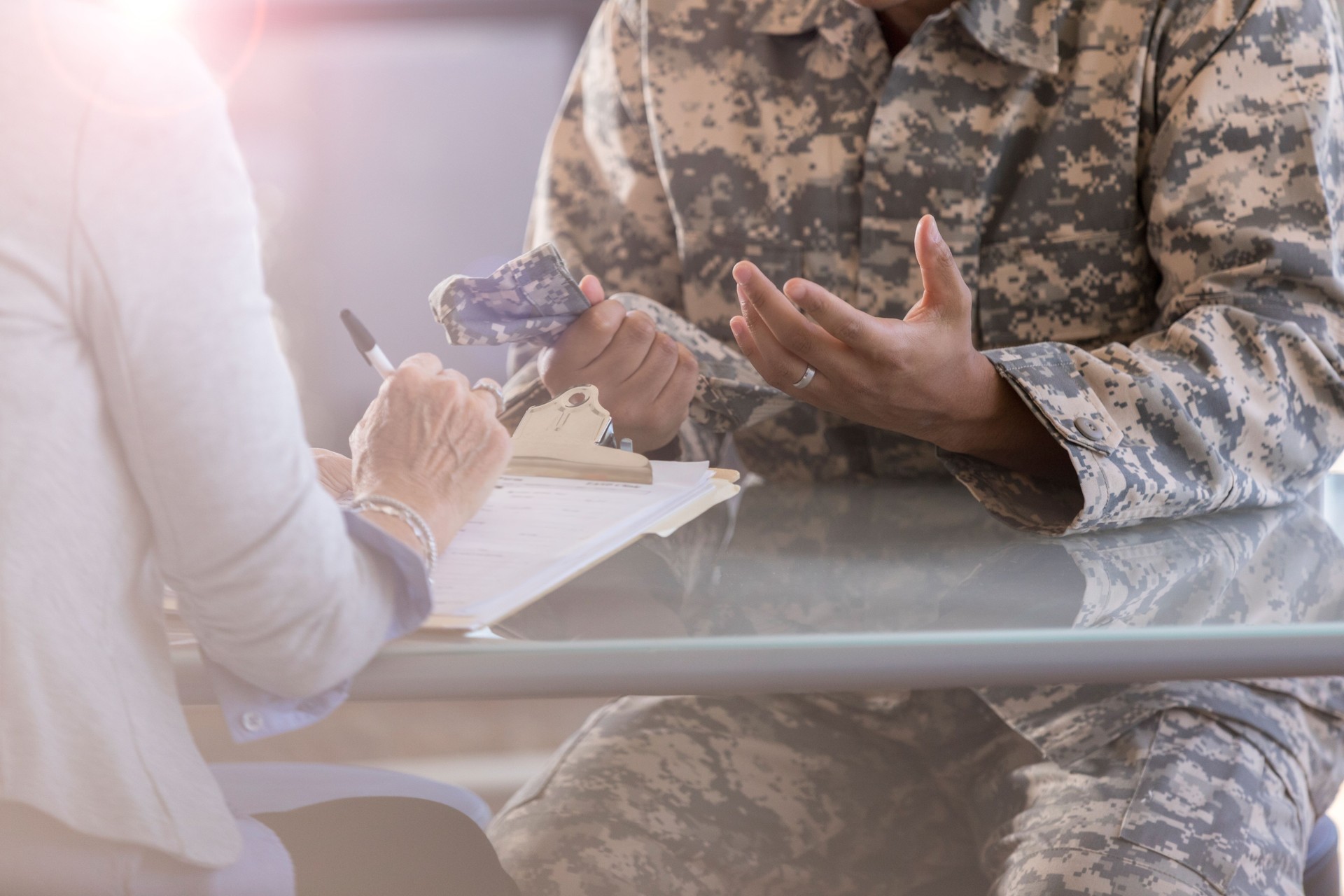 Unrecognizable soldier meets with therapist